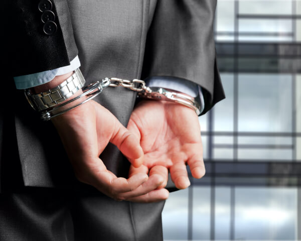 man handcuff's against white collar crimes 